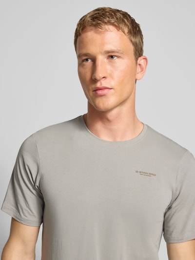 Männermodel trägt Slim Fit T-shirt met ronde hals van G-star, mix van katoen en elastaan, logoprint, heren, nahaufnahme oberkörper.