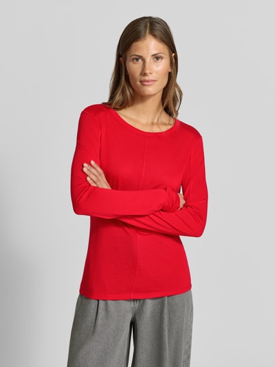 Frauenmodel trägt Longsleeve in semi-transparenter Optik von MYON in Rot, taillierter Schnitt, Ziernaht, Rundhalsausschnitt, Nahaufnahme Oberkörper.