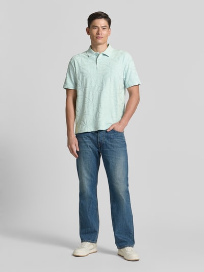 Männermodel trägt Regular Fit Poloshirt aus Baumwoll-Mix Modell 'PE_FLOWER' von BOSS Orange, Optik:Allover-Muster, Struktur, Label-Applikation, Polokragen, V-Ausschnitt, 2-Knopf-Verschluss, Ärmelform: Kurzarm, Rumpfabschluss mit Seitenschlitzen, Materialverarbeitung: Frottee, Ganzkörperansicht von vorne.