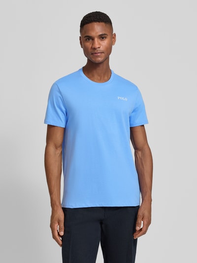 Mannelijk model draagt Regular Fit Pyjama-Oberteil aus reiner Baumwolle Modell 'CREW-SLEEP-TOP' van Polo Ralph Lauren Underwear in effen lichtblauw met logo-opdruk en ronde hals, korte mouw, katoenmateriaal, ganzlichaamsfoto voorkant.