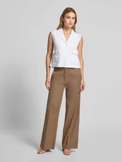 Frauenmodel trägt Weste aus Leinen-Mix mit Pattentaschen Modell 'Lava' von FREE/QUENT in Weiß, kombiniert zu brauner Hose, Ganzkörperansicht von vorne. Regular Fit, Reverskragen, Knopfleiste, leichte Textur.