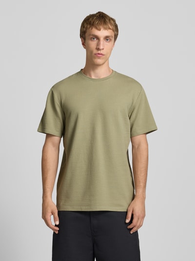 Männermodel trägt Regular Fit T-Shirt aus Baumwoll-Mix Modell 'KIAN' von Only & Sons, Optik: Unifarben, Piqué-Struktur, Ganzkörperansicht von vorne.