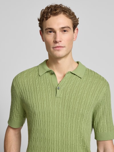 Männermodel trägt Slim Fit Kurzarm Pullover mit Kaschmir-Anteil in Strick-Optik von FTC-Cashmere in Hellgrün, Nahaufnahme Oberkörper.