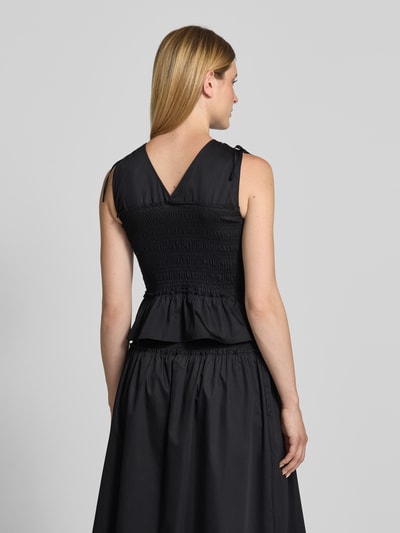 Frauenmodel trägt Blusentop mit Smok-Details von Comma, schwarzer Baumwoll-Mix mit Stretch-Anteil, Regular-Fit, Rückenlänge 45 cm, Ganzkörperansicht Rückansicht.