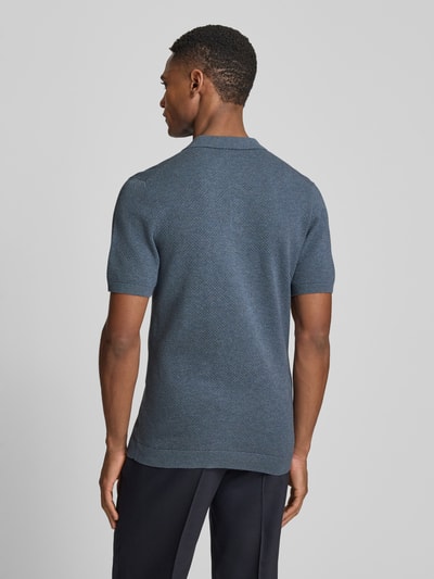 Męski model nosi koszulkę polo Slim Fit Poloshirt Modell 'Triton' od Drykorn z bawełny, fakturowany wzór, krótki rękaw, widok całej sylwetki z tyłu.