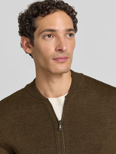 Männermodel trägt Slim Fit Strickjacke aus Baumwoll-Mix mit Stehkragen von Christian Berg Men, Feinstrickstruktur, Nahaufnahme Oberkörper.