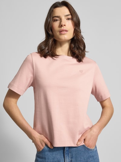 Modelka nosi T-Shirt mit Rundhalsausschnitt und Label-Stitching od Oui z czystej bawełny, krój regular fit, kolor jasnoróżowy, zbliżenie na górną część ciała.