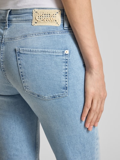 Vrouwenmodel draagt Regular Fit Jeans uit katoenmix model 'PIPER' van Cambio in denimlook met studs, labelpatch, 5-pocketmodel, detailopname.