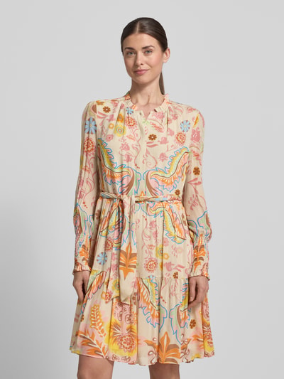 Frauenmodel trägt Regular Fit Kleid mit floralem Allover-Print von HERZENS, Stehkragen, Taillierte Passform, Langärmelig, Stoffband, Knopfleiste, mehrfarbig mit verspielten Mustern, Ganzkörperansicht von vorne.