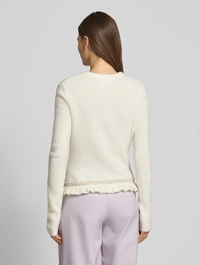 Frauenmodel trägt Slim Fit Cardigan in Strick-Optik Modell 'Kate' von GUIDO MARIA KRETSCHMER WOMAN in Creme mit Rüschen- und Ziersteinbesatz, Ganzkörperansicht Rückansicht