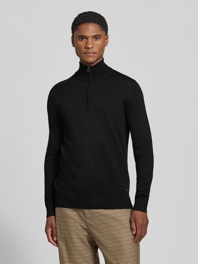 Männermodel trägt schwarzen Modern Fit Troyer aus reiner Schurwolle Modell 'Dario' von JOOP! COLLECTION, Ganzkörperansicht von vorne.