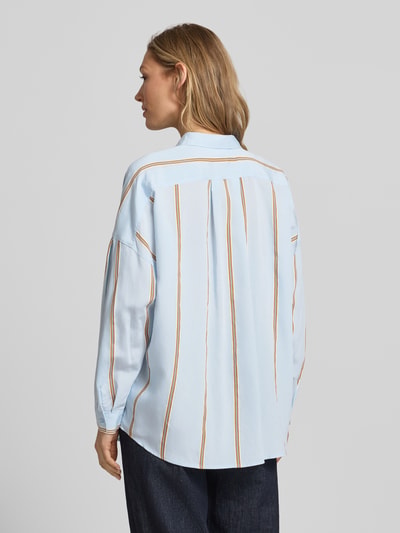 Vrouwenmodel draagt Relaxed Fit Bluse aus Viskose-Mix van Jake*s Casual in lichtblauw met streepmotief, overhemdkraag en knoopsluiting, ruglengte 70 cm, mouwlengte 42 cm, ganzekörperansicht rückansicht.