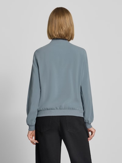 Kobieta nosi Regular Fit Blouson mit Allover-Muster model 'COCO' od VERO MODA w kolorze jasnoniebieskim, gładka tekstura, widok całej sylwetki z tyłu, damska bomberka/bluzon.