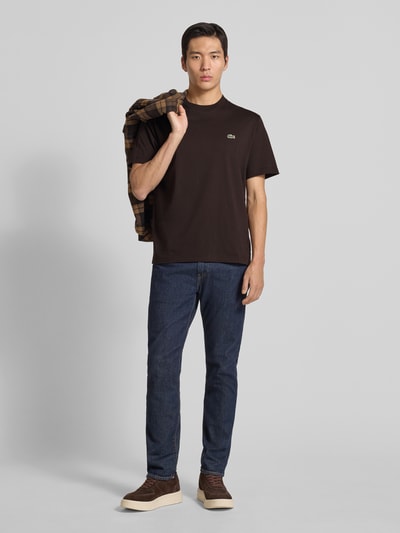 Męski model nosi Regular Fit T-Shirt aus reiner Baumwolle von Lacoste, efekt: jednolity kolor, okrągły dekolt, wyhaftowane logo, naszywka z logo, krótki rękaw, czysta bawełna, Ganzkörperansicht von vorne.