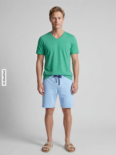 Männermodel trägt Regular Fit T-Shirt mit V-Ausschnitt von MCNEAL aus grüner Baumwolle, schlichter Style, Ganzkörperansicht von vorne.