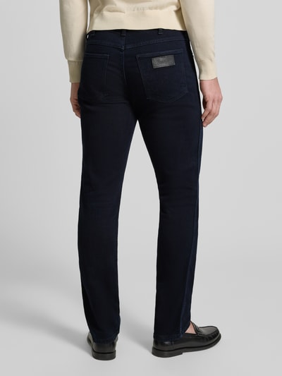 Männermodel trägt Straight Fit Jeans im 5-Pocket-Design Modell 'Greensboro' von Wrangler in dunklem Blau, Baumwoll-Mix, Ganzkörperansicht Rückansicht.