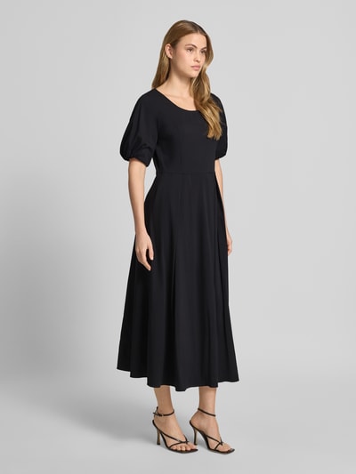 Vrouwenmodel draagt Midikleid met Raffungen van More & More, zwart, katoenmix, getailleerde pasvorm, ronde hals, stolpplooi, halflange mouwen, ruglengte maat 36: 119 cm, borstwijdte maat 36: 44 cm, mouwlengte maat 36: 29 cm, geheel van voren bekeken.