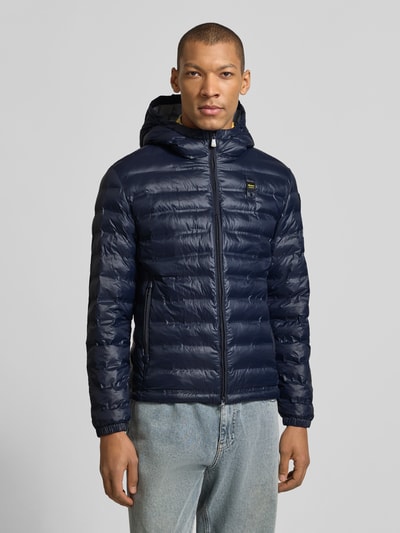 Männermodel trägt Steppjacke mit Zweiwege-Reißverschluss Modell 'Charles' von Blauer Usa, regular Fit, Kapuze, Label-Detail, Ganzkörperansicht von vorne.