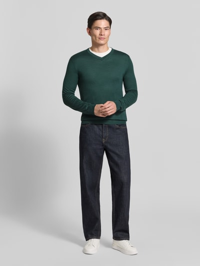 Männermodel trägt Strickpullover aus Woll-Mix mit V-Ausschnitt von Christian Berg Men in Dunkelgrün, Regular Fit, Ganzkörperansicht von vorne.