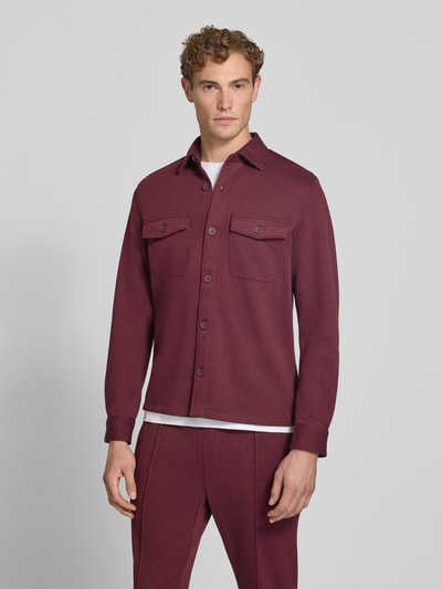 Männermodel trägt Overshirt mit Knopfleiste von MCNEAL in Bordeaux, gerade Form, Brusttaschen, Material-Mix, Ganzkörperansicht von vorne.