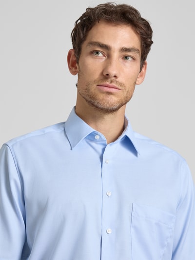 Männermodel trägt Comfort Fit Business-Hemd aus Baumwolle mit Kentkragen von ETERNA in Hellblau, Knopfleiste, Brusttasche, Nahaufnahme Oberkörper. Kontext: Herren Business-Hemd von ETERNA, Reine Baumwolle, Comfort Fit, Kentkragen, Knopfleiste, Brusttaschen, 1/2-Arm, Rückenlänge bei Größe 40: 80 cm, Schulterbreite bei Größe 40: 45 cm, Ärmellänge bei Größe 40: 30 cm.