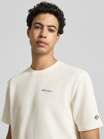 Männermodel trägt T-Shirt mit Strukturmuster und Label-Stitchings von CHAMPION, Cremefarbe, Baumwoll-Mix, Regular-Fit, Nahaufnahme Oberkörper.