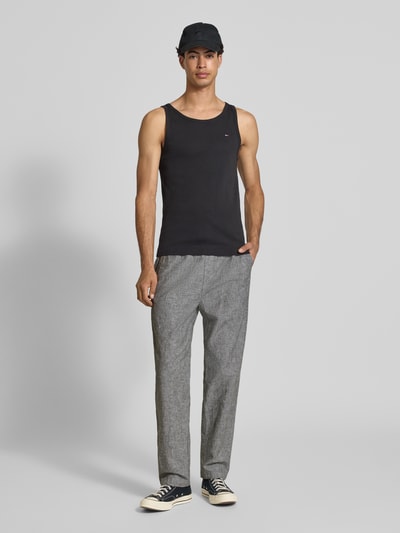 Mannenmodel draagt Regular Fit Weite Hose aus Leinen-Baumwoll-Mix van Tommy Jeans met melangelook, label stitching, tunnelkoord, elastische taille, steekzakken en achterzakken, linnen-katoenmix, flammgaren, grijze tinten, rechte vormen, gladde textuur. Volledige lichaamsaanzicht voorkant.