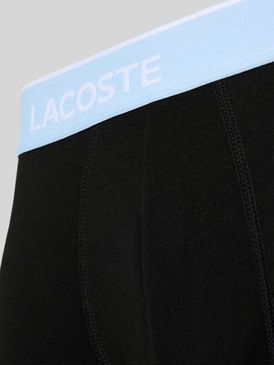 Männermodel trägt zwarte boxershort met lichtblauwe tailleband, katoenmix, Trunk aus Baumwoll-Mix im 3er-Pack van Lacoste, detailopname. Heren Pant & Trunk van Lacoste.