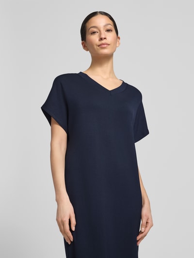 Vrouwenmodel draagt t-shirtjurk met v-hals van Soyaconcept, materiaalmix met modal, recht model, midi-jurk, nahaufnahme bovenlichaam.