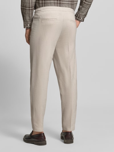 Männermodel trägt Hose mit elastischem Bund Modell 'PILOU' von Casual Friday, Material-Mix mit Leinen-Anteil, Regular-Fit, Beige, Ganzkörperansicht Rückansicht. Bundweite 42 cm, Innenbeinlänge 73 cm bei Größe M.