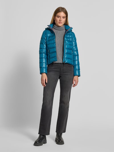 Frauenmodel trägt Regular Fit Jacke in Stepp-Optik von NAUTGÅRD in Blau, mit Kapuze und Reißverschluss, Ganzkörperansicht von vorne. Kontext: Damen Jacke, Stepp-Optik, Kapuze mit Stehkragen, Rückenlänge 55 cm, Schulterbreite 39 cm, Brustweite 49 cm, Ärmellänge 63 cm.
