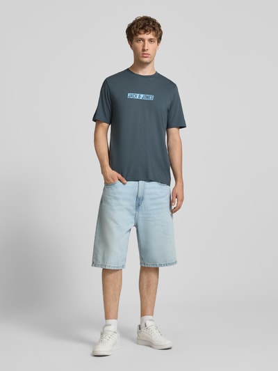 Männermodel trägt Regular Fit T-Shirt mit Logo-Print Modell 'Munk' von JACK & JONES, reine Baumwolle, Ganzkörperansicht von vorne.