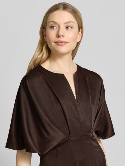 Frauenmodel trägt Midikleid mit V-Ausschnitt Modell 'VIANNA' von Copenhagen Muse in Dunkelbraun, taillierter Schnitt, strukturierte Textur, Nahaufnahme Oberkörper.