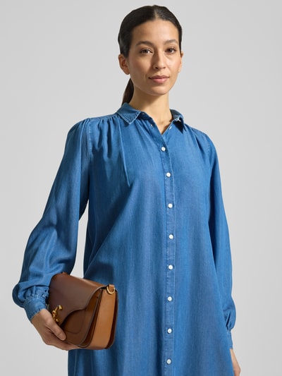 Kobiece modelka nosi Knielanges Hemdblusenkleid in Denim-Optik von Smith & Soul z Lyocellu, prosty krój, długość do kolan, tkanina stylizowana na denim, kołnierzyk koszulowy, listwa guzikowa, długość tyłu w rozmiarze S: 104 cm, szerokość w rozmiarze S: 49 cm, długość rękawów w rozmiarze S: 65 cm, kolor niebieski, gładka tekstura. Zbliżenie na górę ciała.