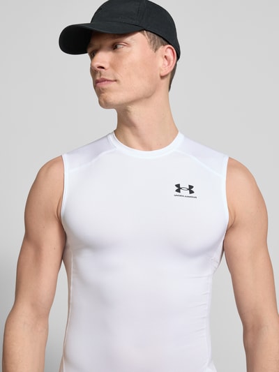 Mężczyzna nosi Slim Fit Top mit Logo-Print od Under Armour, elastyczna mieszanka materiałów, okrągły dekolt, długość tyłu 65 cm, Nahaufnahme Oberkörper.
