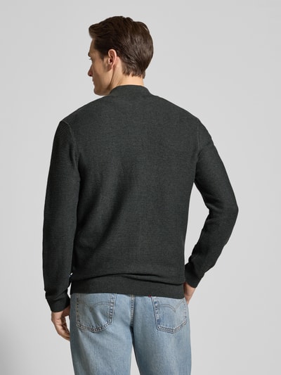 Mężczyznęmodel nosi Regular Fit Cardigan mit Stehkragen od OLYMP Level Five, czarna bawełna, krój regular fit, sweter, zamek, elastyczne wykończenia, długość tyłu M: 68 cm, długość rękawa M: 67 cm, widok całej sylwetki od tyłu.