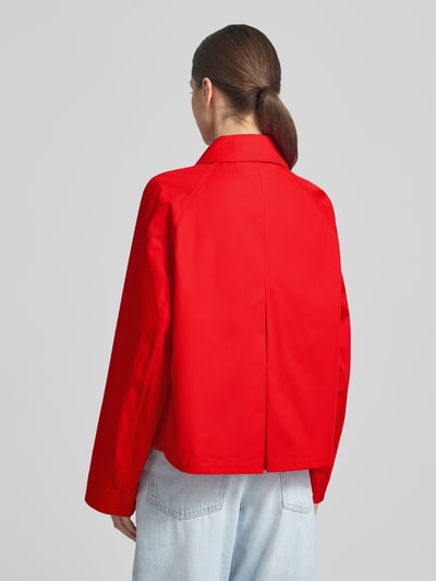 Modelka kobieca ma na sobie Relaxed Fit Trenchcoat aus reiner Baumwolle od Tommy Hilfiger, jednolity czerwony twill, długość cropped, widok całej sylwetki z tyłu.