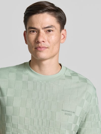 Männermodel trägt Regular-Fit T-Shirt aus reiner Baumwolle Modell 'PS SPIRIT70' BOSS Green X PORSCHE in Hellgrün, dezentes Karo-Muster, Herren T-Shirt von BOSS Green, Nahaufnahme Oberkörper