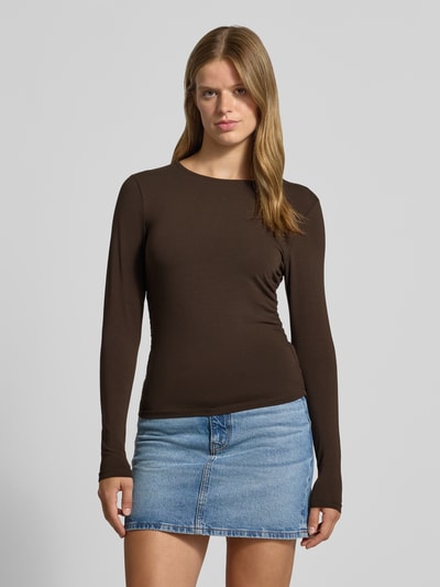 Frauenmodel trägt Regular Fit Langarmshirt aus Baumwoll-Mix Modell 'MIRA' von ONLY in Dunkelbraun zu Jeansrock, Ganzkörperansicht von vorne, Damen Langarmshirt von ONLY