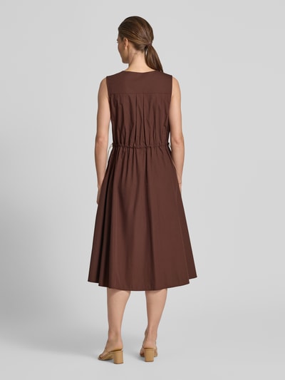 Frauenmodel trägt Knielanges Cocktailkleid mit Kordelzug und Kordelstoppern von Rinascimento aus Reine Baumwolle, Taillierter Schnitt, Knielänge, V-Ausschnitt, Kordelzug-Taille, Rückenlänge 112 cm, Brustweite 47 cm, Ärmellänge 9 cm, warme Braunfarbe, glatte Textur, Ganzkörperansicht Rückansicht.