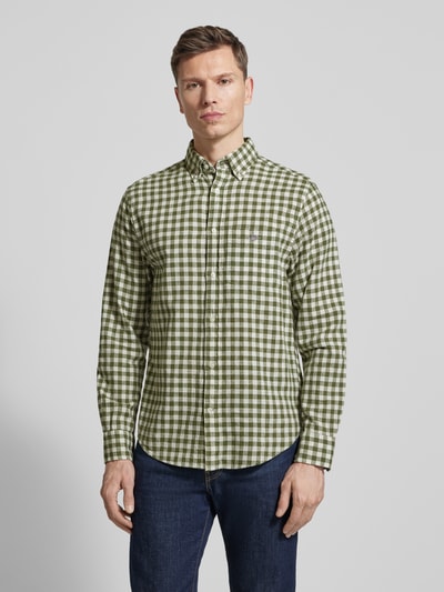 Männermodel trägt Regular Fit Leinenhemd mit Baumwoll-Anteil Modell 'GINGHAM' von Gant in Grün-Weiß kariert, Ganzkörperansicht von vorne. Leinen-Baumwoll-Mix, durchgehende Knopfleiste, Button-Down-Kragen, Brusttasche mit Label-Stitching, langärmelig mit abgerundetem Saum.