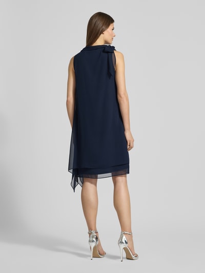 Kobiece modelka ma na sobie Relaxed Fit Sukienka z stójką od Vera Mont, półprzezroczysty materiał, ozdobna kokarda, krój bez rękawów, halka pod sukienkę, długość tyłu w rozmiarze 36: 98 cm, szerokość w rozmiarze 36: 29 cm; pełny widok z tyłu.