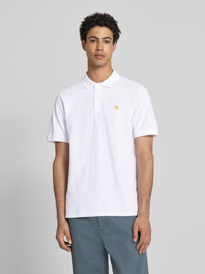 Männermodel trägt Regular Fit Poloshirt mit Label-Stitching von Carhartt Work In Progress aus Reine Baumwolle in Weiß, Knopfleiste, Polokragen, Rückenlänge bei Größe M 73 cm, Ganzkörperansicht von vorne.