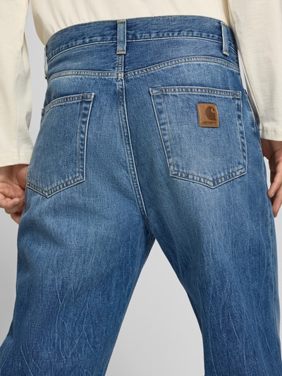 Männermodel trägt Straight Fit Jeans reiner Baumwolle Modell 'Aaron' von Carhartt Work In Progress, 5-Pocket-Design, mittleres Blau, Detailaufnahme Rückansicht.