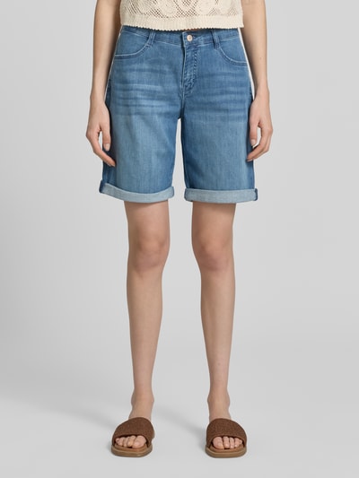 Frauenmodel trägt Bermudas mit Eingrifftaschen Modell 'Summer Clean' von MAC aus Baumwoll-Mix mit Stretch-Anteil in Blau, Straight Fit, sichtbarer Knopf- und Reißverschluss, seitliche Eingrifftaschen, Gesäßtaschen, glatte Jeansstruktur, Ganzkörperansicht von vorne.