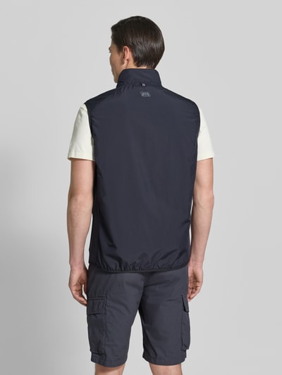 Männermodel trägt Regular Fit Weste mit gefüttertem Stehkragen von camel active in Dunkelblau, elastischer Bund, Ganzkörperansicht Rückansicht.