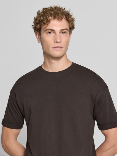Męski model nosi Regular Fit T-Shirt aus reiner Baumwolle Modell 'Thilo' von DRYKORN w kolorze ciemnobrązowym, okrągły dekolt, Długość tyłu w rozmiarze M: 71 cm, zbliżenie na górną część ciała