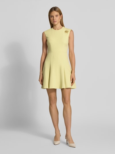 Frauenmodel trägt Figurumspielendes Freizeitkleid mit Brosche aus Metall Modell 'KILANDI' von HUGO, Optik: Unifarben, Passform: Figurumspielend, Länge: Knielang, Ausschnitt: Rundhals, Applikation: Brosche aus Metall, Verschluss: Nahtreißverschluss, Ärmelform: Ohne Ärmel, zartes Gelb, glatte Oberfläche, Ganzkörperansicht von vorne.