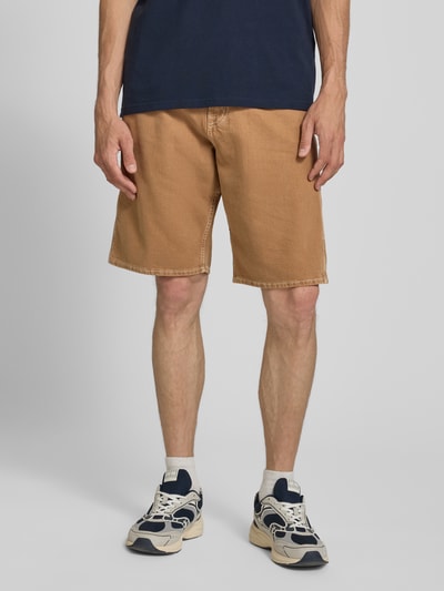 Męski model nosi szorty jeansowe Baggy Fit z wpuszczanymi kieszeniami model 'ALEX' od JACK & JONES, bawełna, szerokość w rozmiarze M 46 cm, długość wewnętrzna nogawki 28 cm, widok z przodu całej sylwetki