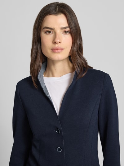 Modelka kobieca nosi Blazer mit Stehkragen und Eingrifftaschen od WHITE LABEL, mieszanka bawełny, taliowany krój, listwa guzikowa, wpuszczane kieszenie, granatowy, szerokość w rozmiarze 36: 45 cm, długość tyłu w rozmiarze 36: 80 cm, długość rękawów 64 cm, zbliżenie na górną część ciała z przodu